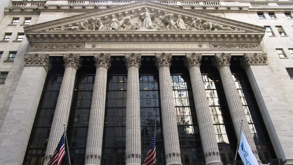 Prédio da Bolsa de Valores de Nova York, com colunas e bandeira americana na fachada